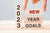 new year new me, a hand placing goals for 2023